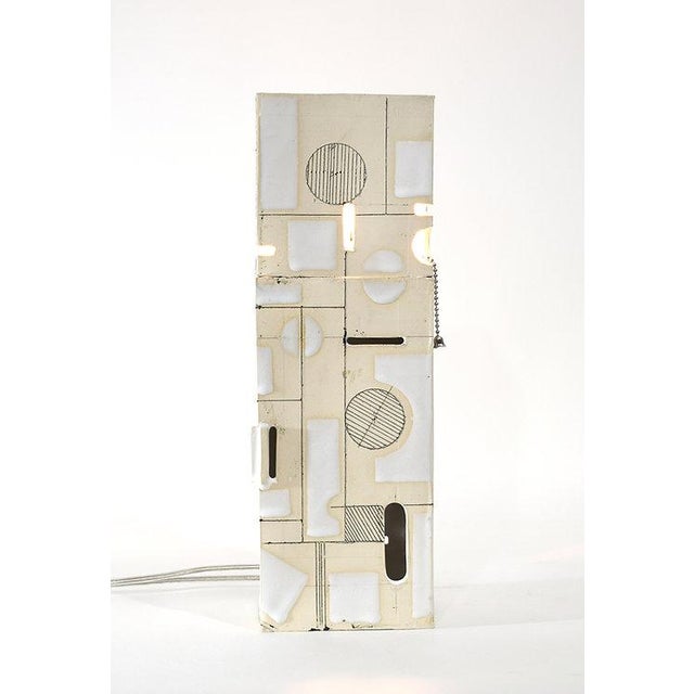 This extended lamp form explores the relationship between line, opening, and light across an expanded vertical field....