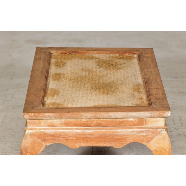 This low vintage coffee table blends rustic character with sculptural form, featuring a rectangular wooden frame set over...