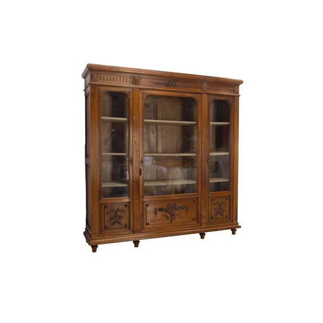 A grand louis xvi-style bookcase crafted around 1900 from solid oak and walnut veneer. This elegant piece stands out for...
