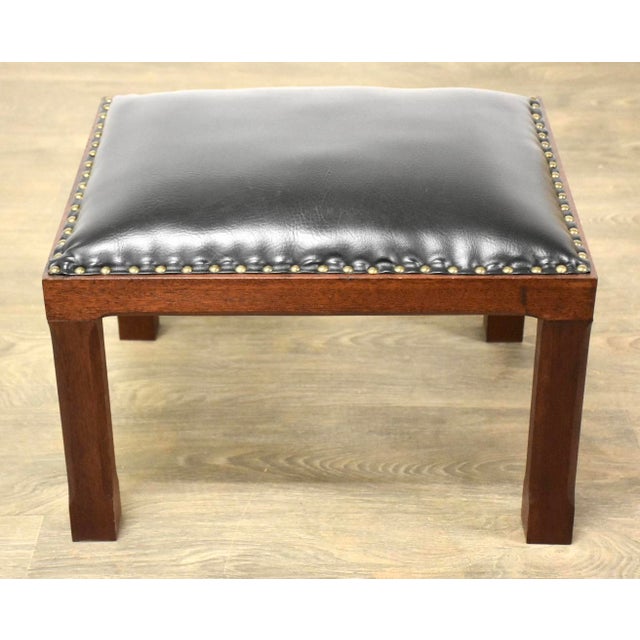 A solid mahogany and black vinyl ottoman stool which would pare well with mid century modern furniture or arts and crafts...