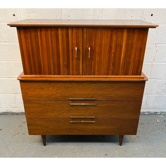 A timeless example of American mid-century modern design, this Young Manufacturing walnut highboy dresser combines...