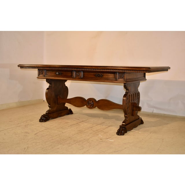 Circa 1920's walnut library table or writing desk from Italy. The top has lovely graining and has a beveled edge with a...
