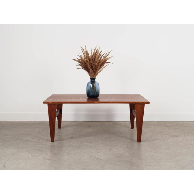 The coffee table was made in the 1970s in Denmark. The tabletop is made of solid oak. The legs are covered with teak...