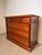 Elegant cherrywood chest of drawers featuring a timeless design with warm wood tones and refined brass-effect hardware....