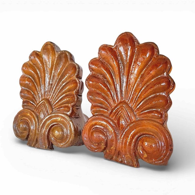 A sophisticated pair of antique terracotta architectural antefixes featuring a classic palmette or anthemion motif....