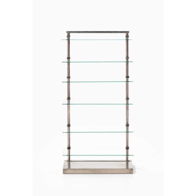 This rare glass and steel shelf, produced by a. Ravenel in france, is a compelling example of mid-century industrial...