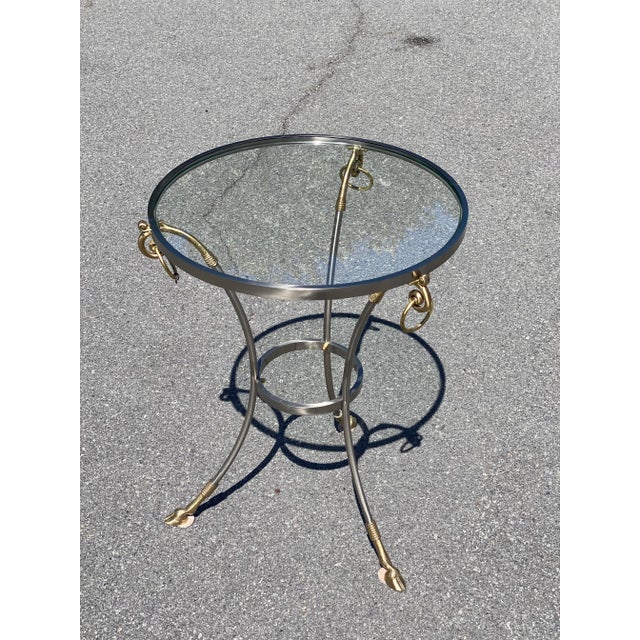 This is a fabulous vintage steel and brass Gueridon table with a glass top. The round table frame is made of steel with...