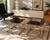 A sophisticated pair of vintage chrome, brass, and smoked glass side tables by Maison Jansen. Their restrained...