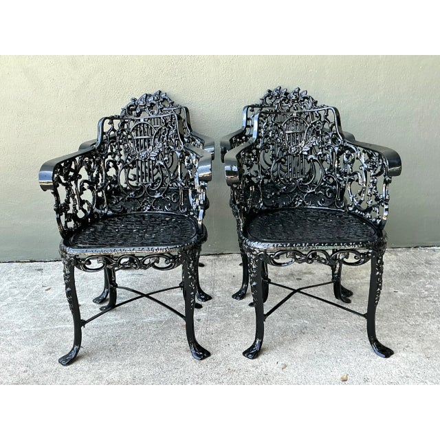 Showcasing ornate classical details, this set of four vintage outdoor armchairs features elaborate lyre-motif backrests...