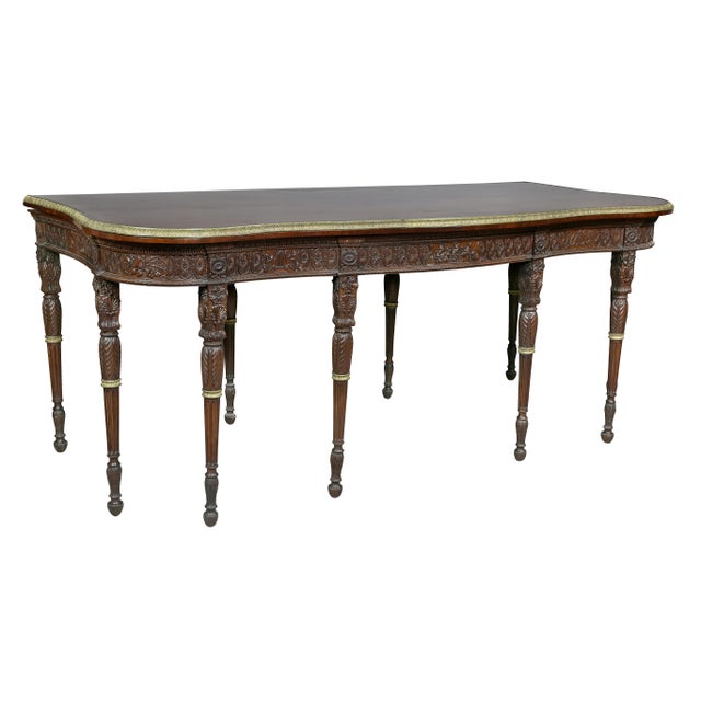 With serpentine top with cast brass edge and also crossbanded edge over a conforming frieze finely carved with paterae,...