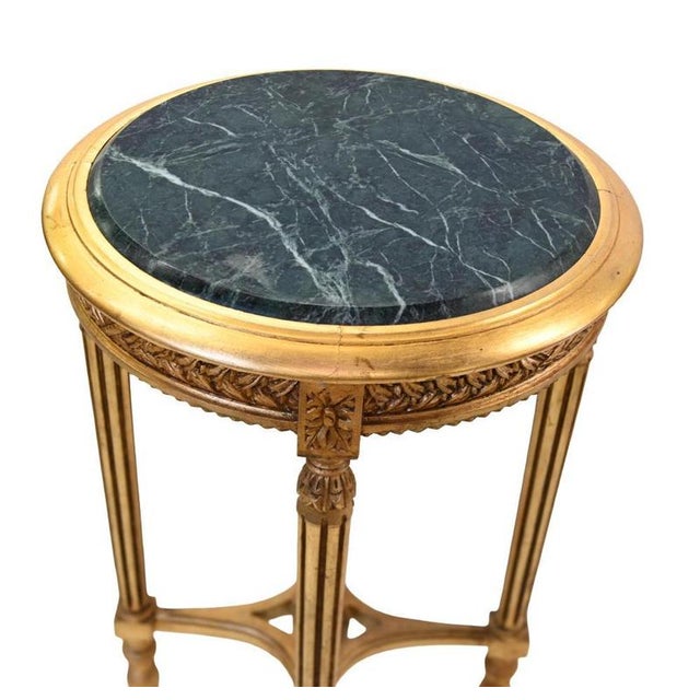 Elegant pair of Louis XVI style occasional tables with circular marble tops The dark marble displays contrasting pale...