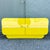 A bold postmodern chest of drawers featuring a vibrant high-gloss yellow laminate finish with sculptural waterfall edges...