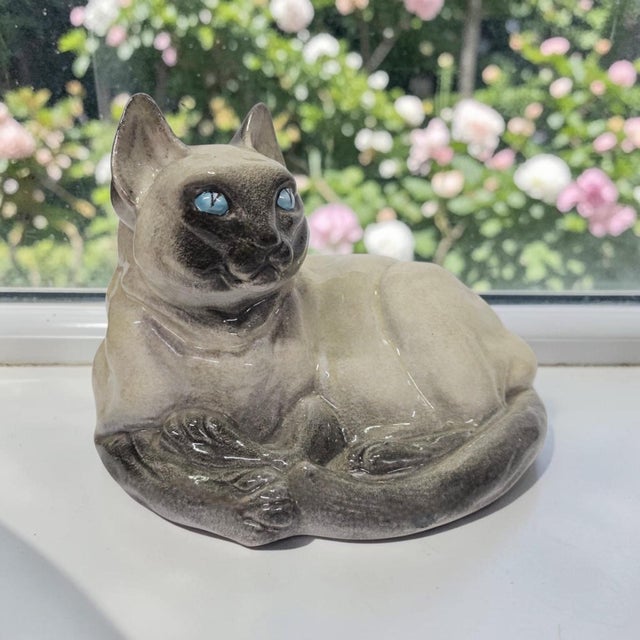 Realistic Italian pottery reclining Siamese cat figurine is produced circa 1965–1975. Executed in hand-glazed terracotta...