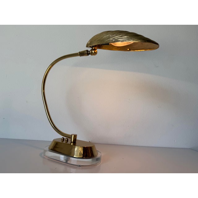 An elegant vintage table lamp featuring a beautifully sculpted brass mussel shell shade with finely textured detailing,...