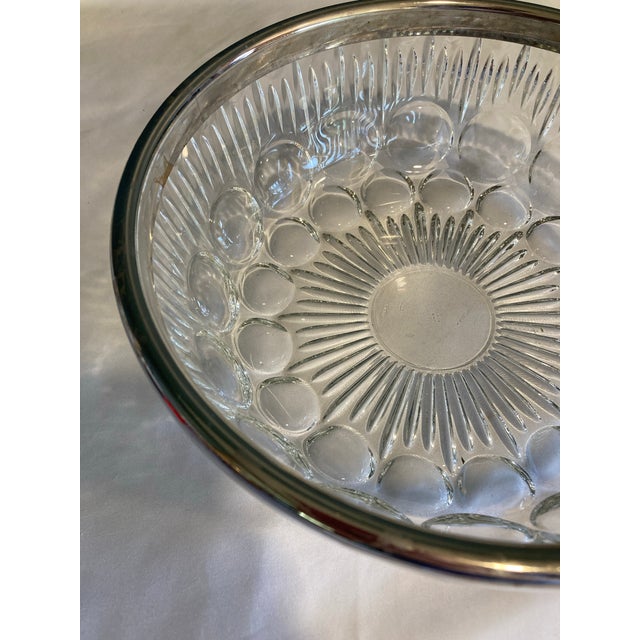 This beautiful cut glass bowl has a lovely bubble pattern. The edge has a metal rim that makes it stand out. . Very pretty...