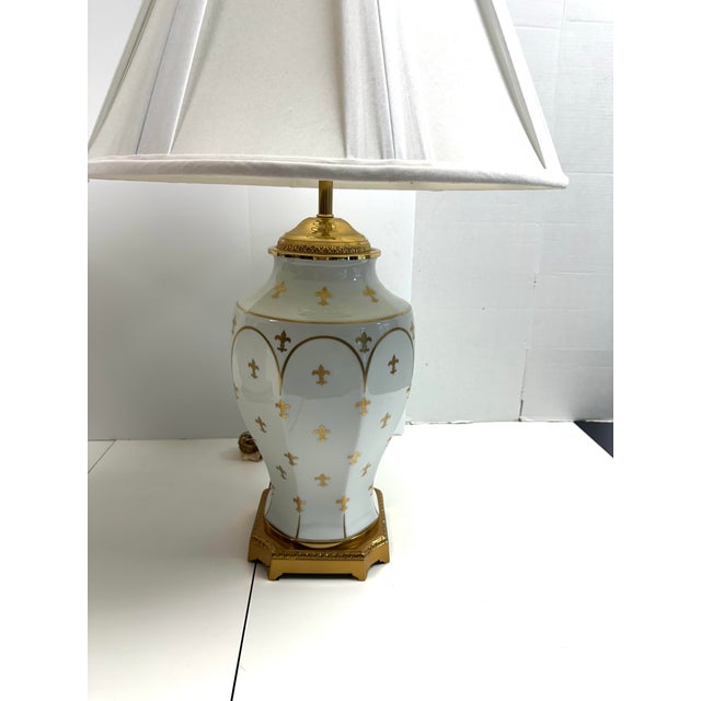 Beautiful pair of hand painted Fleur de lis table lamps on an ornate gold base. Each lamp measures 31 inches high by 8.5”...