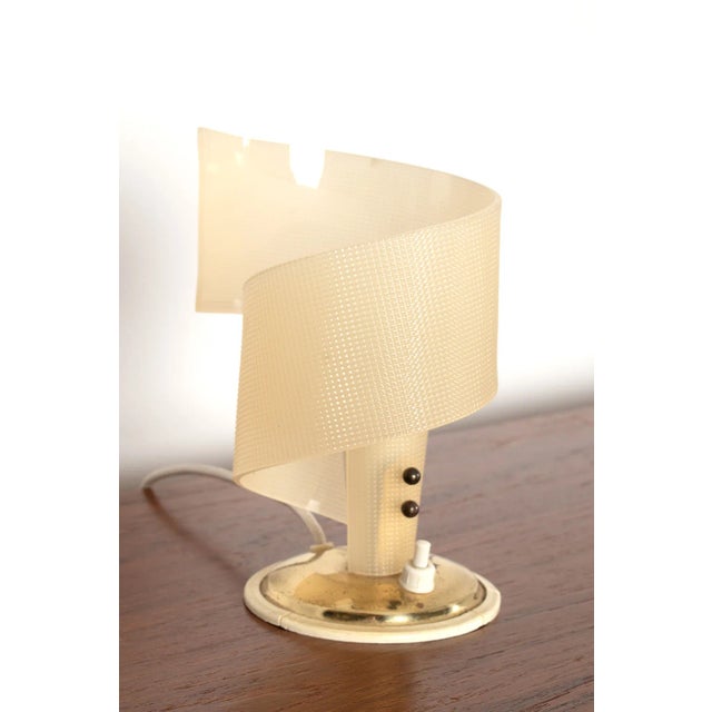 This fun lamp made by Geru in the fifties has a beautiful spheric light. The shade is made from plastic and it has a brass...