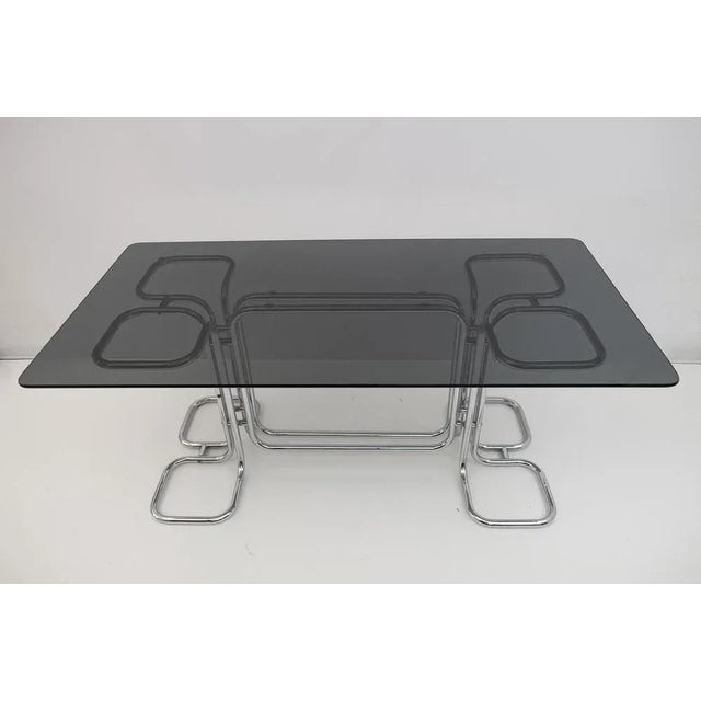 Rectangular dining table with Mid-Century chrome base and smoked glass top. This wonderful dining table was designed by...