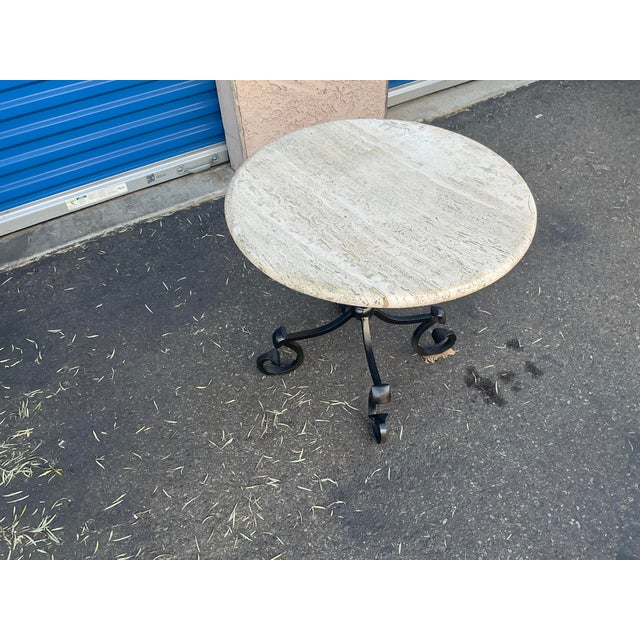 Kreiss iron decorative iron base with travertine top. Base is solid iron. Top is cream colored travertine. Table is in...