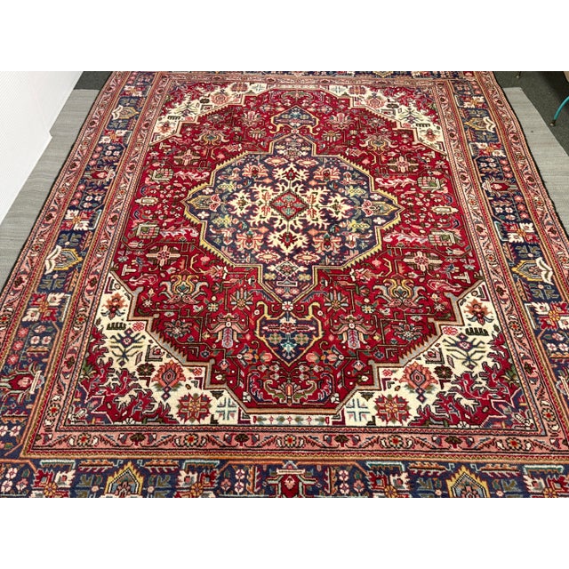 Design Plus Gallery presents a 6ft 7in × 9ft 6in Vintage Persian Tabriz Area Rug. This traditional Tabriz rug displays an...