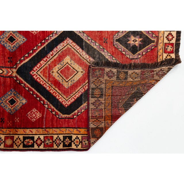 An exquisite mid-20th-century Vintage Kurdish Tribal Rug, hand-knotted by nomadic weavers using 100% natural hand-spun...