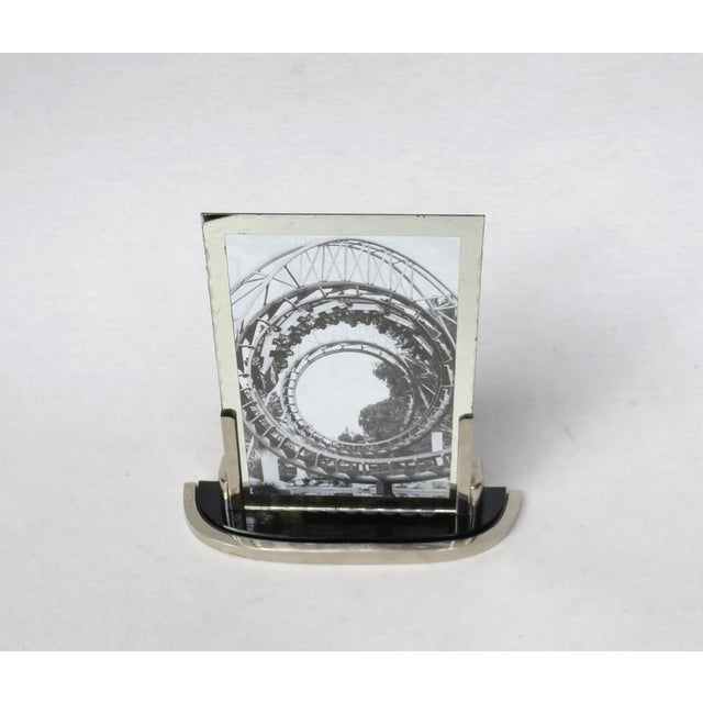An elegant picture frame in the strict design language of Art Deco in the color combination silver and black. He is...