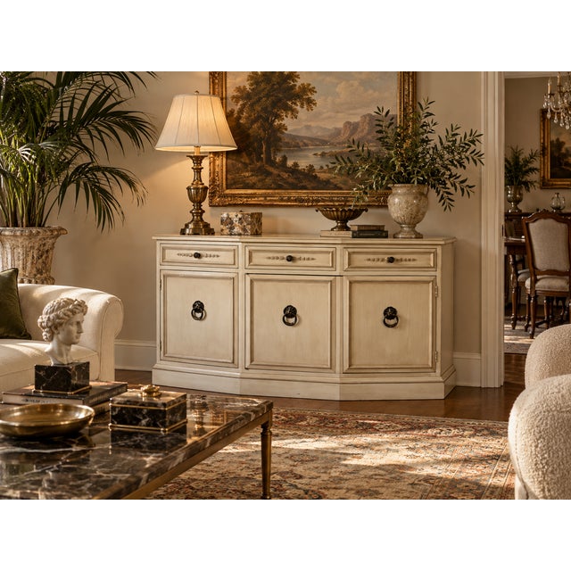 Vintage Hickory Manufacturing Co. bow-front sideboard featuring a soft cream finish, decorative paneled fronts, and ornate...
