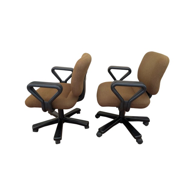 For sale: a pair of earth brown fabric swivel office chairs with black plastic frame and armrests. The chairs offer...