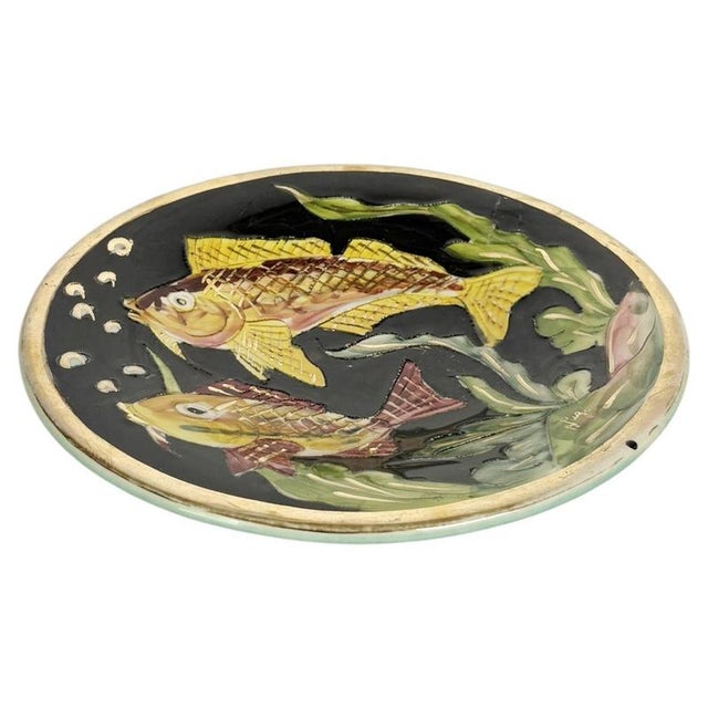Decorative ceramic trinket tray featuring two colorful fish swimming among aquatic plants against a deep black glazed...