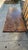 Rustic coffee table is constructed from a thick, solid wood slab with a live edge. The wood has a dark brown stained...