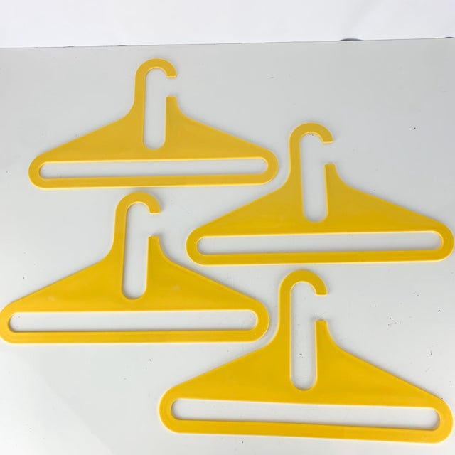 Incredible lot of four hard plastic yellow vintage clothes hangers in the style of Danilo Silvestrin. Vibrant color....