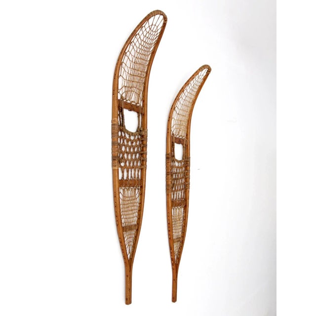 A pair of vintage C.A. Lund snowshoes distinguished by their elongated trail-style silhouette and beautifully rustic...