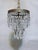 An exquisite vintage crystal waterfall chandelier featuring an elegant, tiered silhouette and beautifully detailed brass...