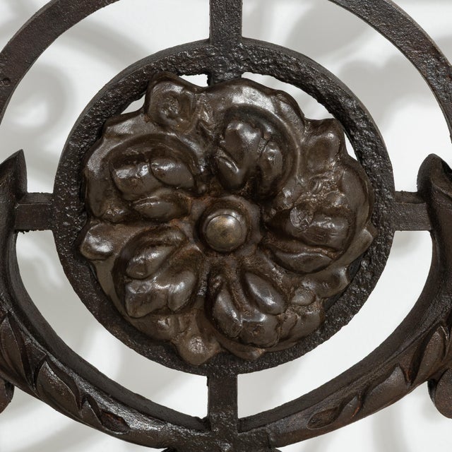 A wrought iron console table with a stone top in a neoclassical style. The open base allows for a lighter visual presence...