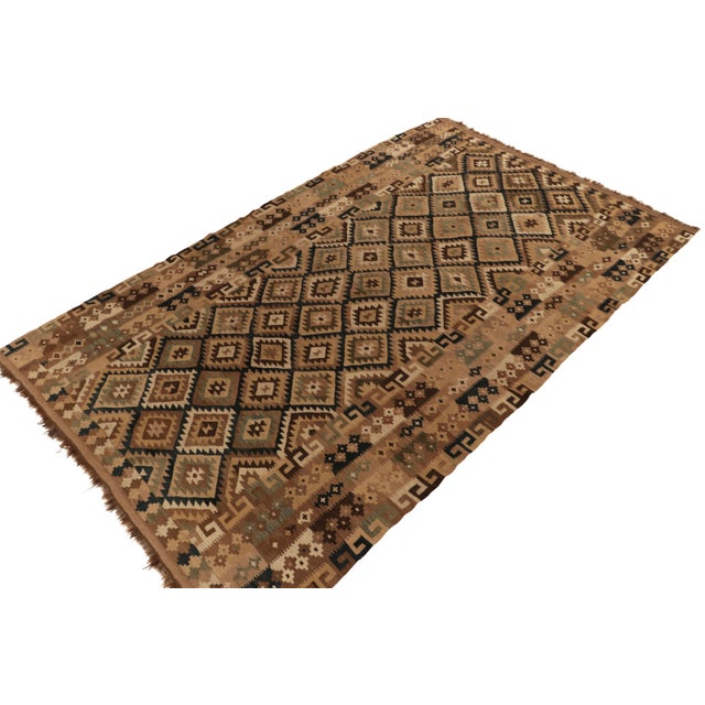 Handwoven in wool, an 8x13 vintage kilim rug from Afghanistan circa 1950-1960. The bold design prefers beige-brown and...