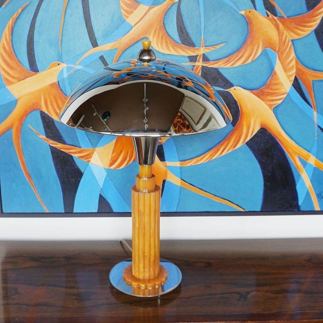 An Art Deco style dome lamp. Fluted orange bakelite stem over a circular chromed metal base. Chromed metal shade with...