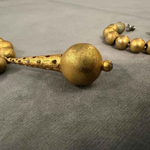 This striking pair of 1980s Italian costume earrings features a bold gilt-metal design with graduated spherical beads and...
