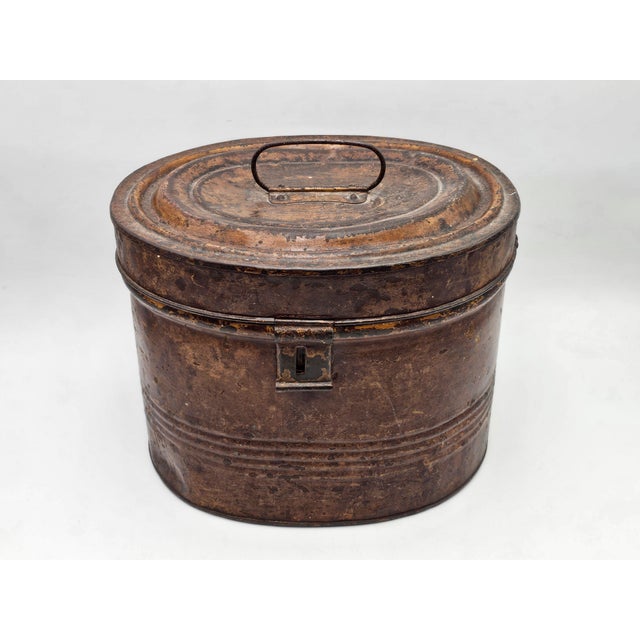 Large, early 1900s English sheet metal box with an oval base, likely used for carrying hats or groceries. Very fine...