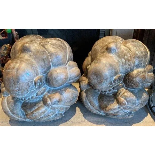 Offered is a pair of hand-carved matching Suar wood sculptures, figure of a man in a loin cloth sitting cross legged and...