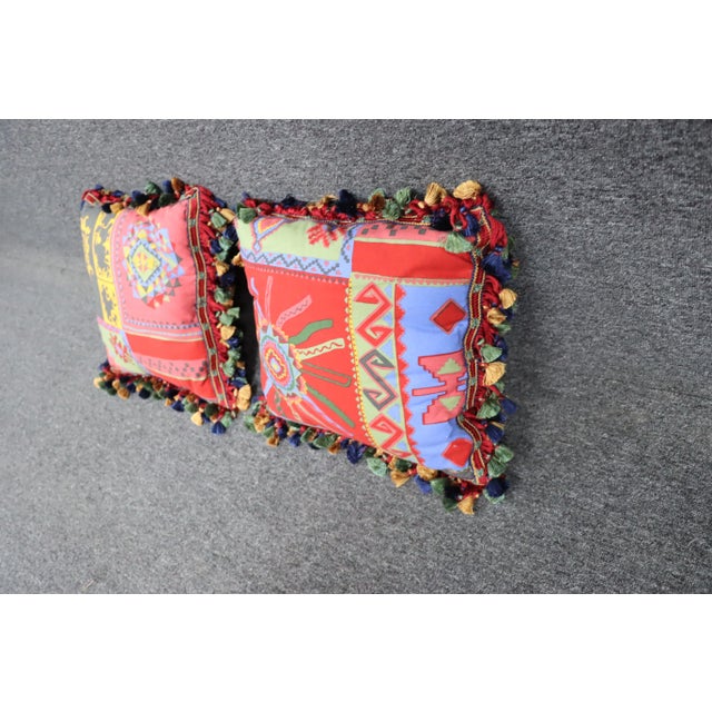 A pair pf Southwestern style throw pillows with tassel accents.