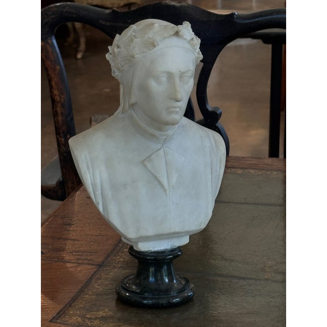 Alabaster bust of Dante, carved with his characteristic laurel-wreathed cap and draped robe, the head turned slightly...