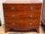 19th century mahogany bowfront chest with a crossbanded top over three long dovetailed drawers, each fitted with oval...