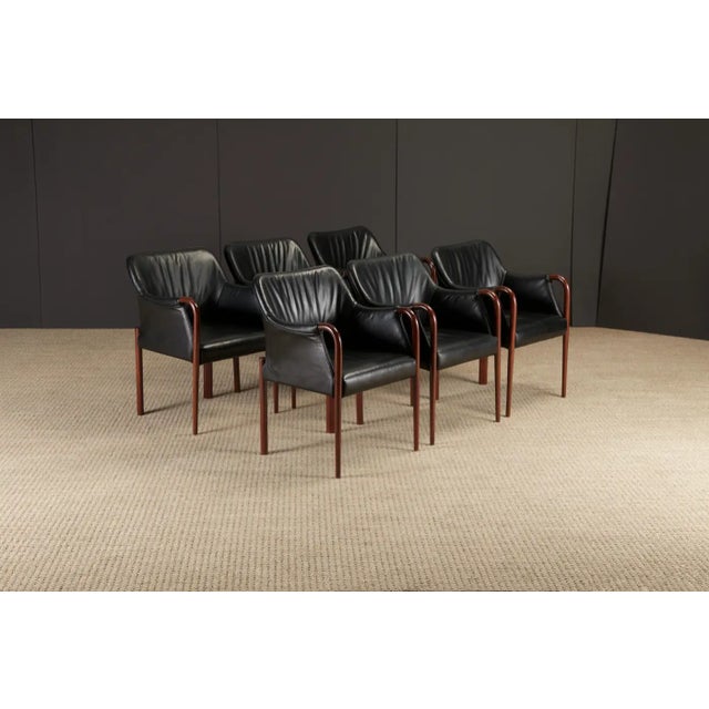 An intriguing set of six black leather and sculpted wood armchairs. We are not certain the particular design, however one...