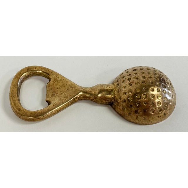 Vintage solid brass bottle opener in shape of golf ball. Patina to brass.