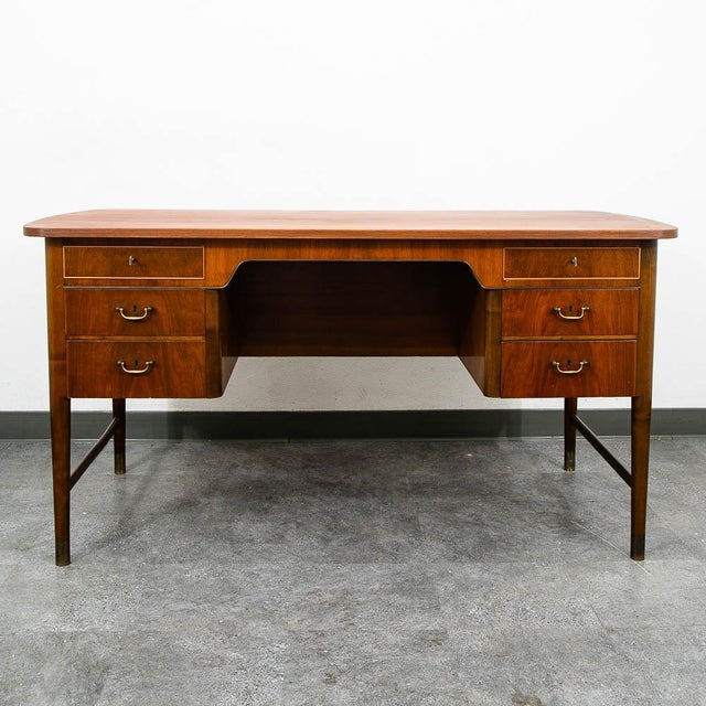 Danish executive desk constructed of beautifully grained walnut wood. This desk has 6 locking drawers, solid brass...