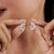 These contemporary openwork stud earrings feature a delicate floral-inspired cluster design with pear-shaped moissanite...