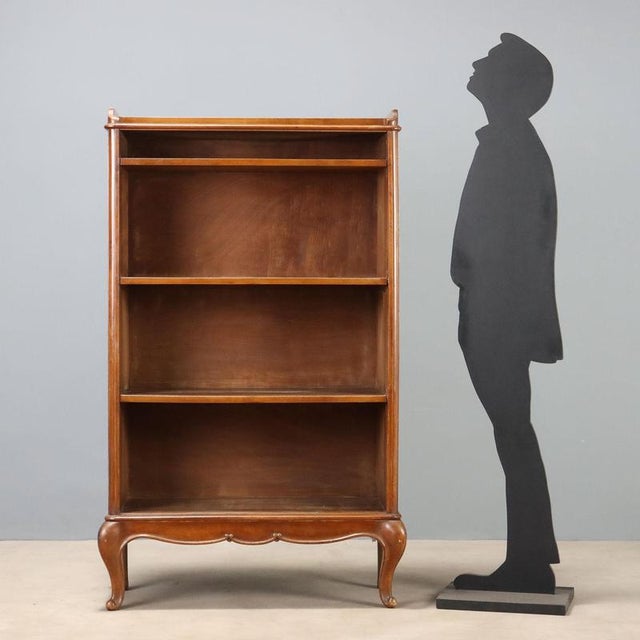 Open walnut bookcase crafted in Italy in the first half of the 20th century. Featuring an elegant structure, it has a...
