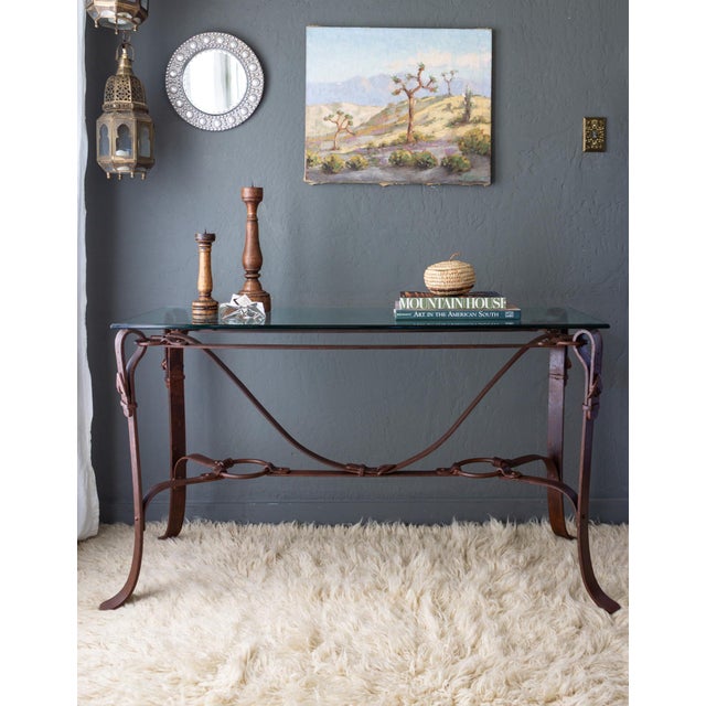 A console table designed with faux leather bridle straps in the manner of Jacques Adnet for Hermes. The heavy iron frame...