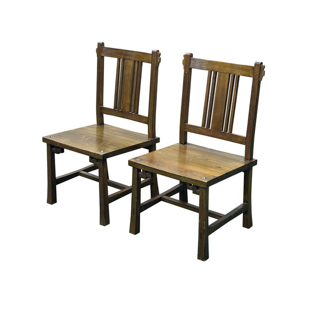 This exceptional pair of vintage solid wood side chairs beautifully bridges Arts and Crafts utility with subtle East...