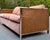 A striking vintage sleeper sofa featuring a polished chrome frame, woven cane side panels, and blush velvet upholstery....